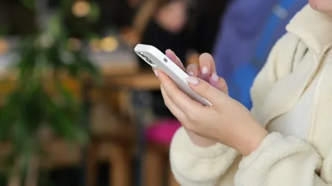 Person using smartphone while seated indoors Stock Footage 345863283