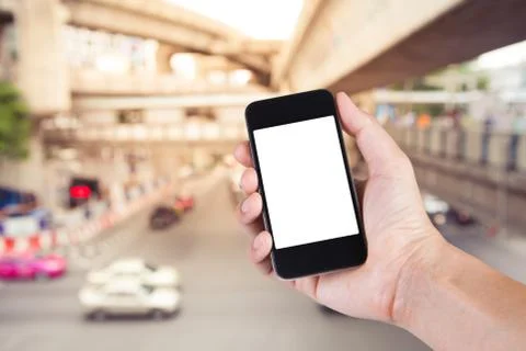 Person using smartphone white screen holder on hand with  blurry of traffic j Stock Photos
