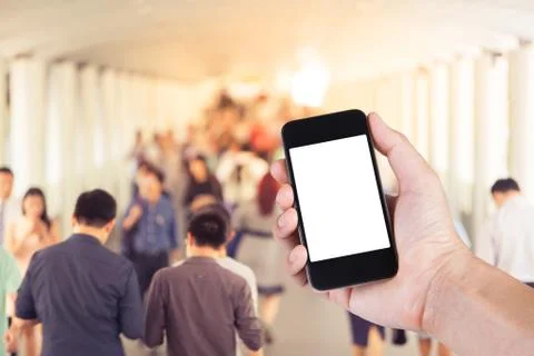 Person using smartphone white screen holder on hand with  many people walking Stock Photos