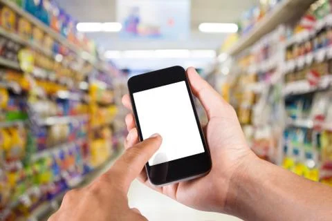 Person using smartphone white screen holder on hand with shelves on backgroun Stock Photos