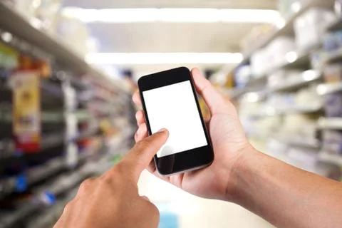 Person using smartphone white screen holder on hand with shelves on backgroun Stock Photos