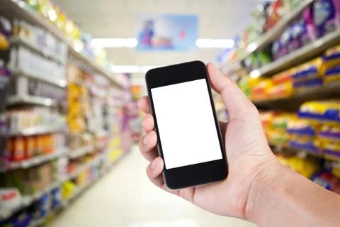 Person using smartphone white screen holder on hand with shelves on backgroun Stock Photos
