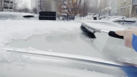 A person is using a snow brush to clear snow off a car 스톡 동영상 271079739