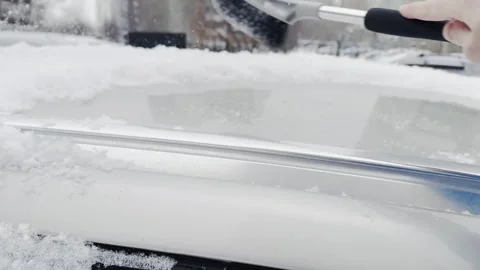 A person is using a snow brush to clear snow off a car Stock-Footage 276065510