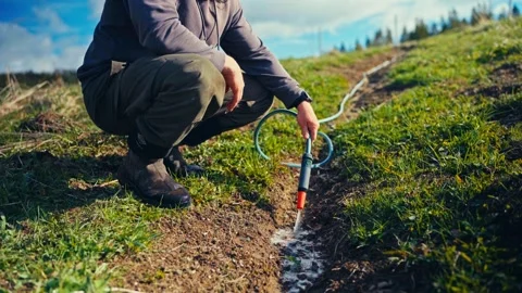 Person Using Soil Injection Probe In Grassy Field Stock Footage 346569332