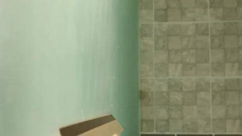 Person Using Squeegee on Steamy Glass Surface to Remove Moisture in Bright Stock-Footage 315181348