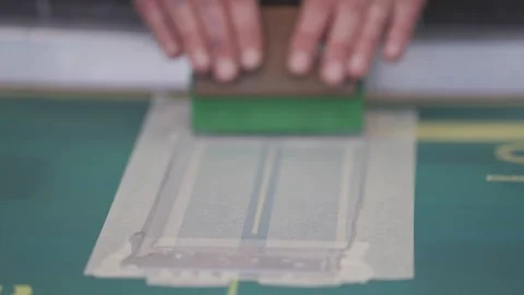 A person is using a stamp to apply a design to a piece of paper Video stock 302457004