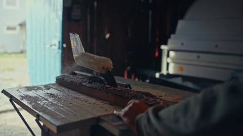 A Person is Using a Table Saw to Cut a Piece of Wood on a Workbench Indoors - Stock Footage 336122614