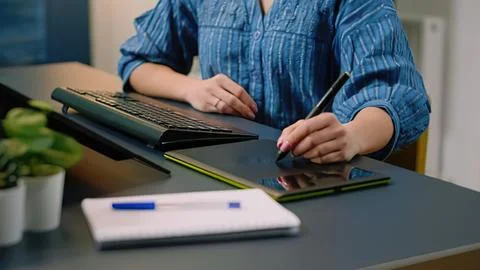 Person using tablet and stylus on desk Stock Photos