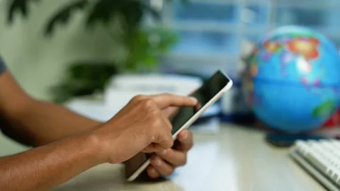 Person using tablet beside globe at desk, Close-up of a person using a tabl.. 스톡 동영상 346484196