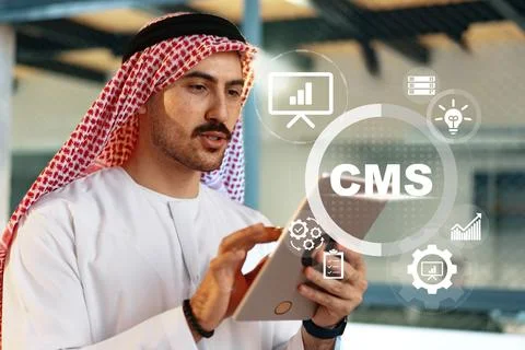 Person using a tablet with CMS tools in a modern office setting in Dubai Stock Photos