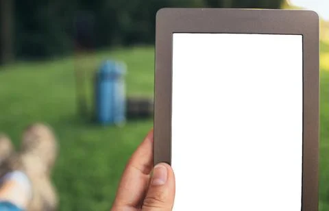 Person using tablet computer while relaxing at green grass after hiking 写真素材