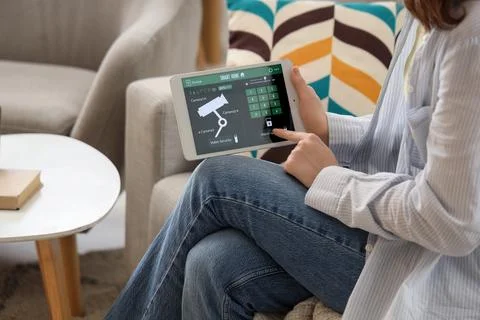Person using tablet to control smart home security system Stock Photos