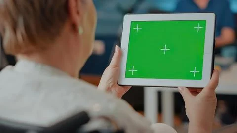 Person using tablet with green screen and plus signs Stock Photos