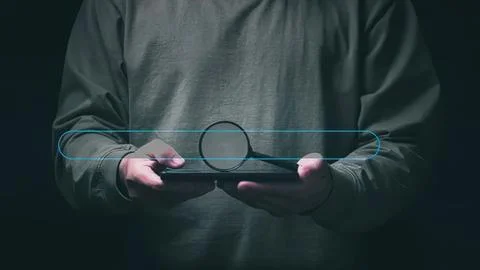 Person using a tablet with holographic interface in dark room Stock Photos