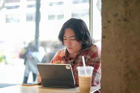Person using tablet with iced drink nearby Stock Photos