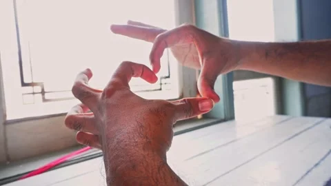 A Person Using Their Hands To Form A Heart Shape In Front Of A Bright Windo.. Stock Footage 345139531