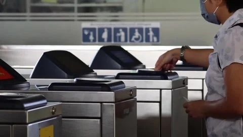 Person using ticket gate for entry in transportation station footage. 스톡 동영상 333835347