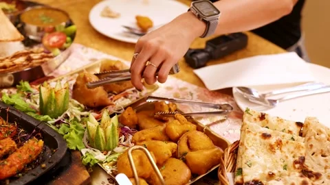 Person Using Tongs to Serve Samosas at Indian Food Feast Stock Footage 340006002
