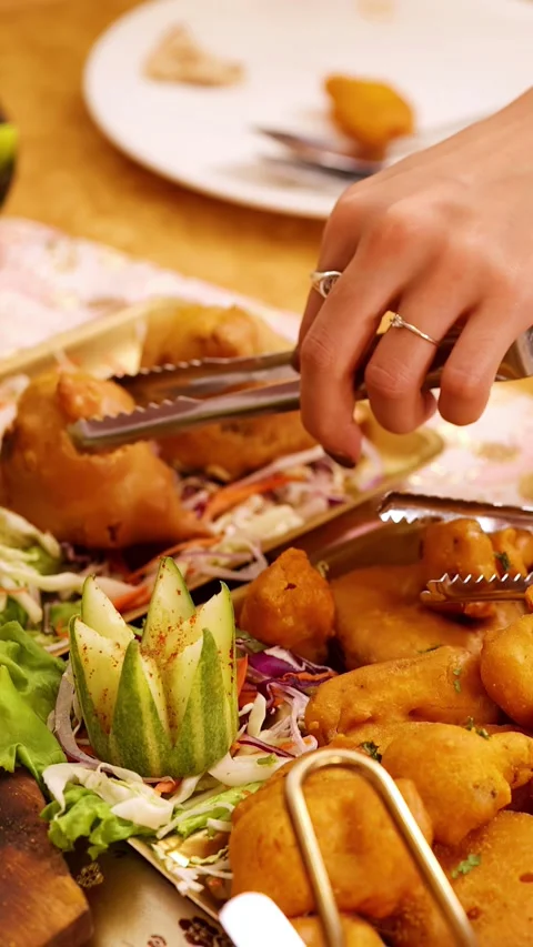 Person Using Tongs to Serve Samosas from Indian Food Platter Stock Footage 340247533