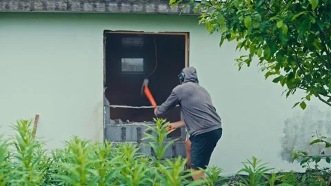 A Person is Using a Tool to Break Through a Wall - Static Shot Stock Footage 334023928
