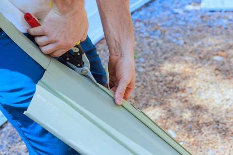 Person using tools to cut facade siding in construction area Stock Photos