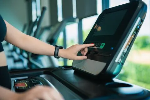 Person using treadmill control panel in gym pressing button to start workou.. Stockfoto's