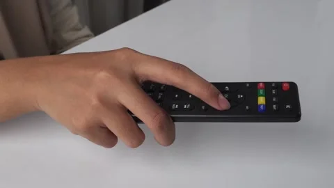 Person using tv remote on white table Stock Footage 276716945