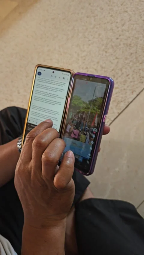 Person Using Two Smartphones Simultaneously Multitasking And Scrolling Video stock 340029376
