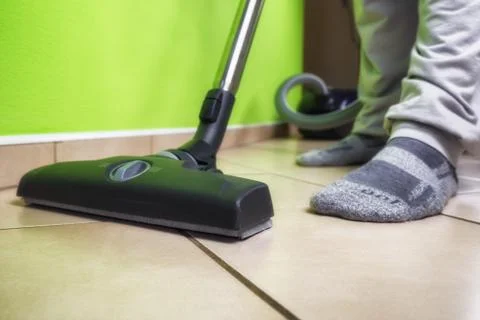 Person using vacuum cleanener while cleaning floor at home Stock Photos
