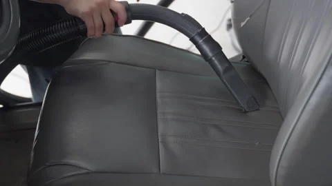 A person using vacuum cleaner to suck out dirts from a car seat Stock Footage 246119741