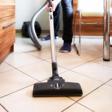 Person using vacuum cleaner while cleaning floor at home Stock Photos