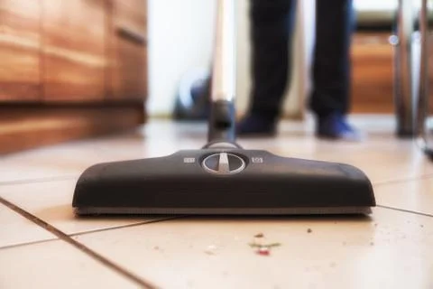 Person using vacuum cleaner while cleaning floor from the dirt Stock Photos