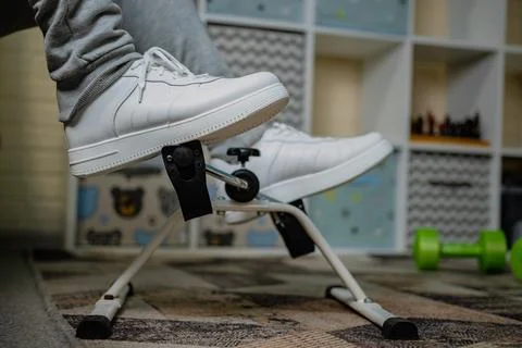 Person Using White Peddler Exercise Machine While Sitting Stock Photos