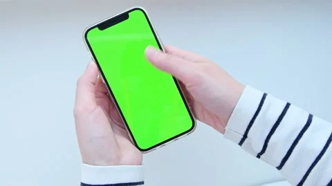 Person views scrolls the screen of a smartphone device. The screen is green Stock Footage 225677239
