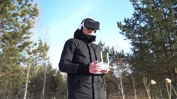 A person in virtual reality glasses controls a drone on the background of the fo Vídeo Stock 85994834