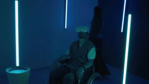 Person in virtual reality headset sitting in dark room Fotos de archivo