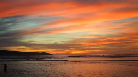 Person wading in the ocean at sunset. Stock Footage 88406384