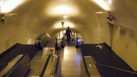 A person walking alone in a Subway station with illuminated escalators. Stock Footage 305459552
