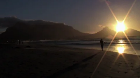 Person walking along the beach at sunset Stock Footage