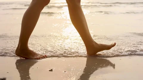 Person walking on the beach at sunset during summer vacation holidays Stock Footage 137314338