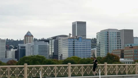A person walking on Burnside Bridge in front of Portland Oregon skyline. Vidéo 168866176