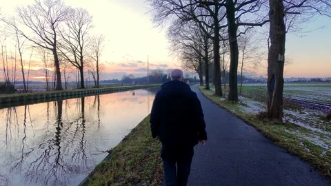 Person walking by the canal at sunset Video stock 324496034