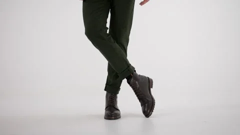 Person walking, dancing, and twisting in brown leather boots and green pants Stock Footage 335939734