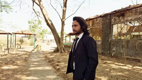 Person walking on a dirt path by old buildings with trees in the background.. Stock Footage 270197944