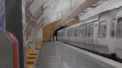 Person walking down metro platform as subway train stops in Paris city center Video stock 305755908