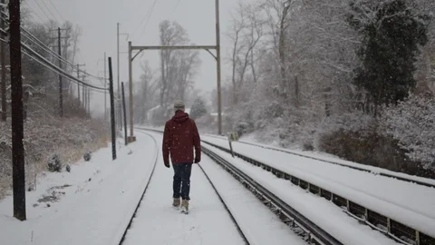 Person walking down train tracks in the snow Video stock 91014707