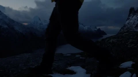 Person walking in front of camera with snowy Norwegian fjords as backdrop 스톡 동영상 308728308