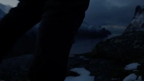 Person walking in front of camera with snowy Norwegian fjords as backdrop Video stock 308728312