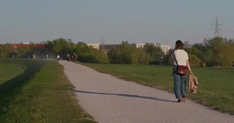 Person walking on paved path in park 库存影片 332550879